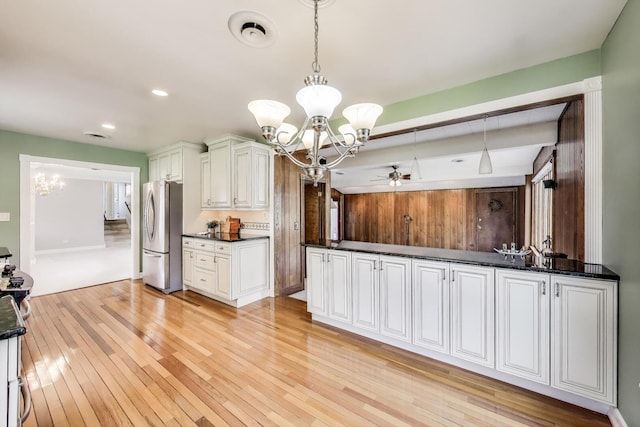 kitchen with pendant lighting, light wood-style flooring, ceiling fan with notable chandelier, and freestanding refrigerator
