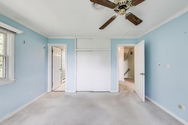 unfurnished bedroom with a closet, a baseboard heating unit, ceiling fan, light colored carpet, and baseboards