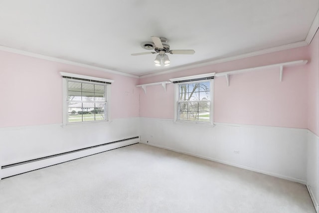 carpeted spare room featuring baseboard heating, ornamental molding, and ceiling fan