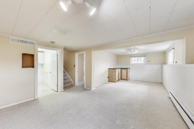 below grade area featuring stairway, a baseboard radiator, baseboards, carpet flooring, and visible vents