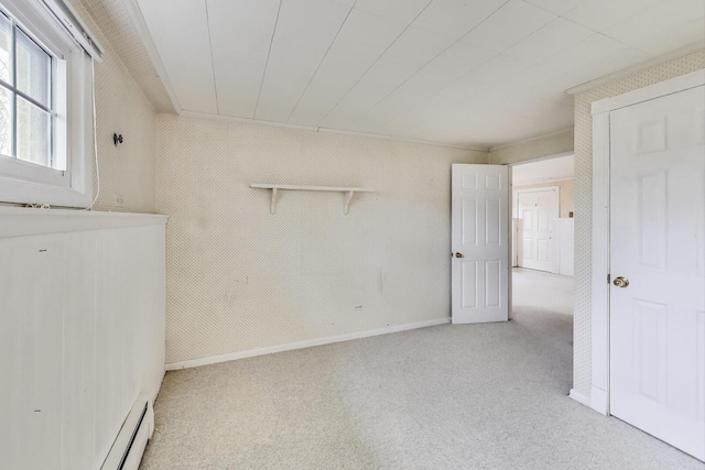 carpeted spare room featuring baseboard heating