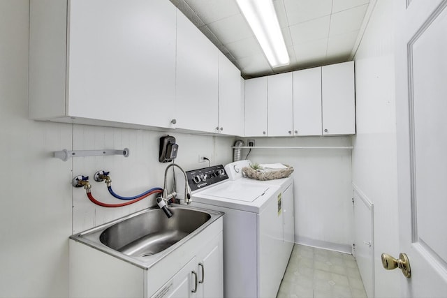 clothes washing area featuring cabinet space, washer and clothes dryer, and a sink