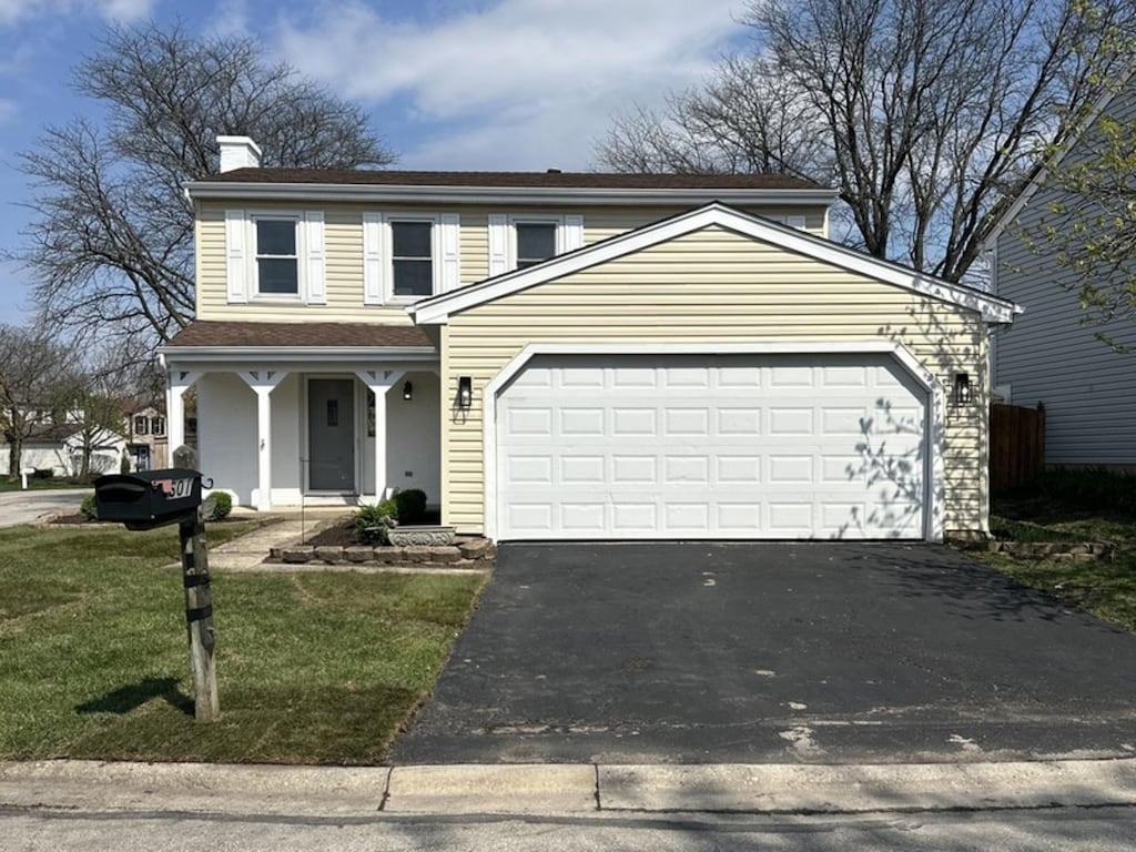 601 Oswego Dr, Carol Stream, IL 60188 - traditional-style home with a porch, a chimney, a garage, a front yard, and aphalt driveway