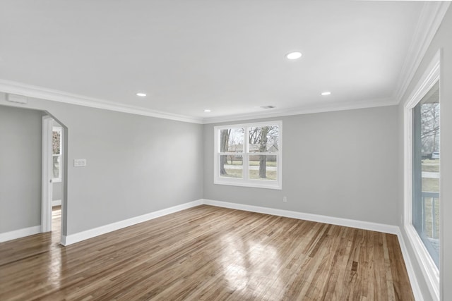 unfurnished room with wood finished floors, a wealth of natural light, and baseboards