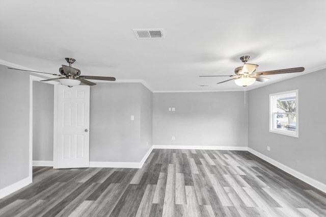 unfurnished room featuring visible vents, crown molding, dark wood-style floors, and ceiling fan