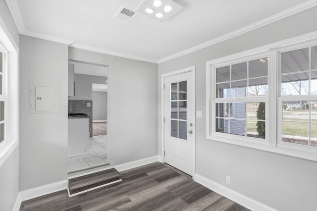 doorway with baseboards, visible vents, dark wood-style floors, and ornamental molding