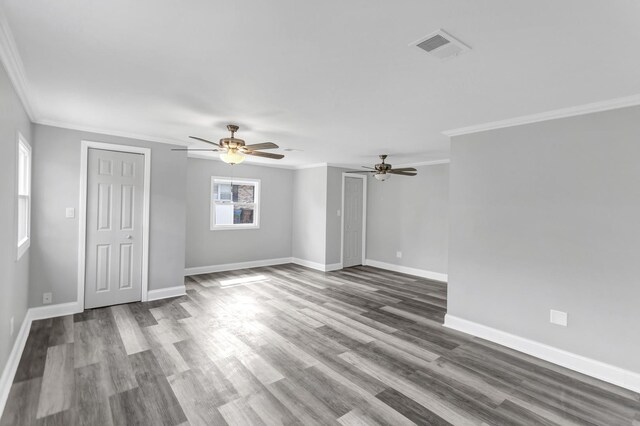 unfurnished room with visible vents, crown molding, baseboards, and a ceiling fan