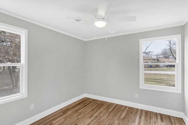 empty room with wood finished floors, baseboards, a ceiling fan, and crown molding
