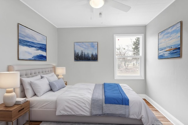 bedroom featuring baseboards, wood finished floors, ceiling fan, and crown molding