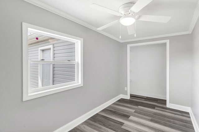 spare room with wood finished floors, crown molding, baseboards, and ceiling fan