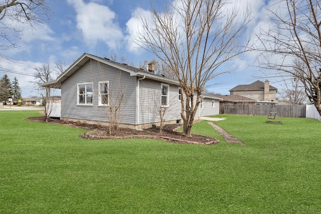 view of property exterior featuring a lawn and fence