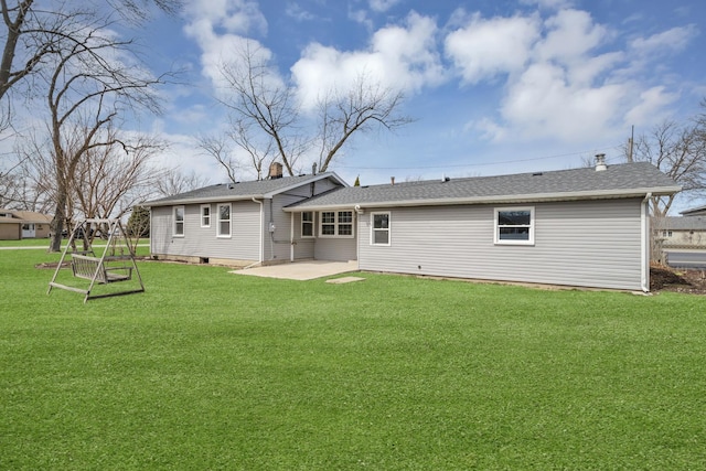 back of property featuring a patio area, a lawn, and a shingled roof