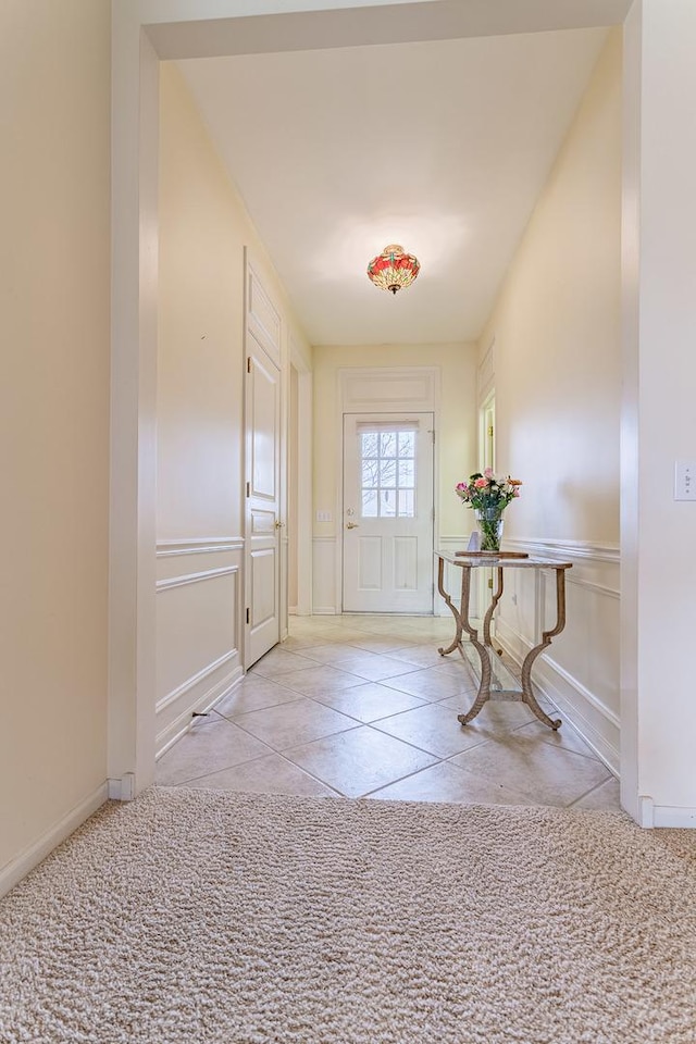 doorway to outside with tile patterned floors and baseboards
