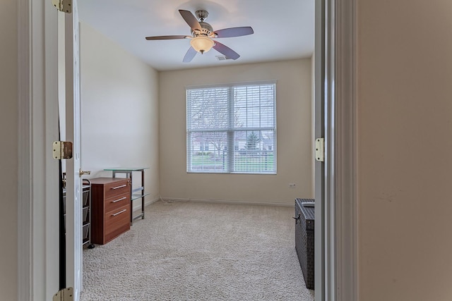 interior space with baseboards, carpet, and ceiling fan