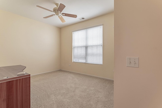 spare room featuring light carpet, baseboards, visible vents, and ceiling fan