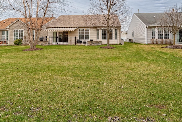 back of property with a yard and central AC unit
