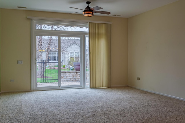 spare room with baseboards, visible vents, carpet floors, and ceiling fan