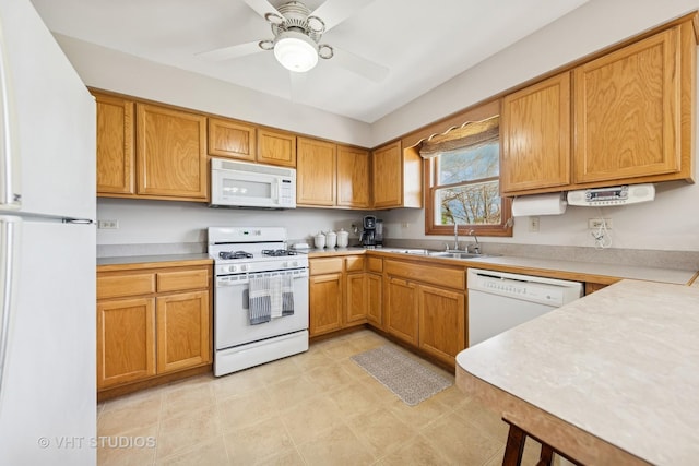 kitchen with a sink, ceiling fan, white appliances, and light countertops