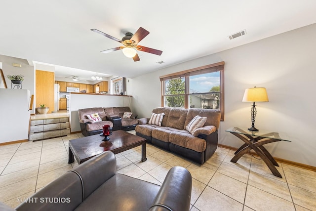 living area featuring a ceiling fan, baseboards, visible vents, and light tile patterned floors
