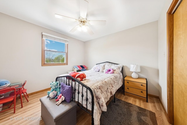 bedroom featuring baseboards, light wood finished floors, and ceiling fan