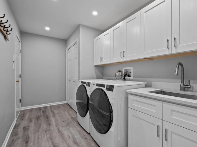 clothes washing area with recessed lighting, light wood-style flooring, separate washer and dryer, a sink, and cabinet space