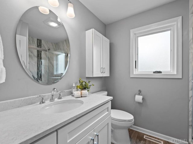 full bath featuring visible vents, a stall shower, vanity, baseboards, and toilet