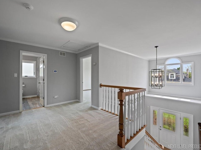 hall with an upstairs landing, carpet, ornamental molding, and visible vents