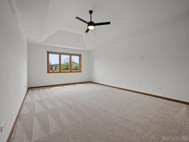 unfurnished room featuring carpet floors, baseboards, ceiling fan, and a tray ceiling