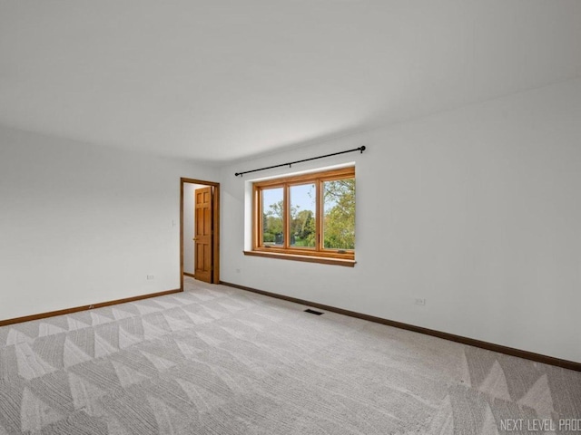 unfurnished room with baseboards, visible vents, and light colored carpet