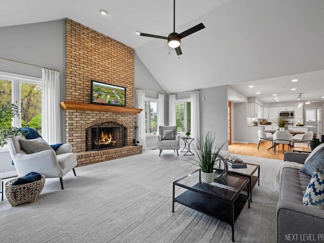 living area with high vaulted ceiling, ceiling fan, a fireplace, and recessed lighting