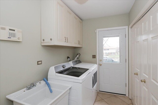 clothes washing area featuring cabinet space, separate washer and dryer, light tile patterned flooring, and a sink