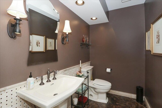 bathroom featuring toilet, a sink, and recessed lighting