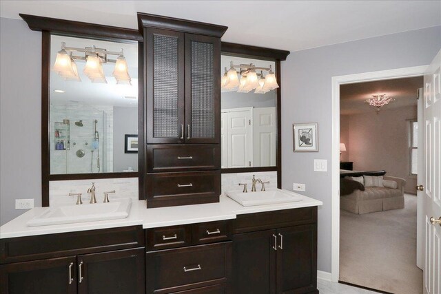 full bathroom with a shower stall, decorative backsplash, and a sink