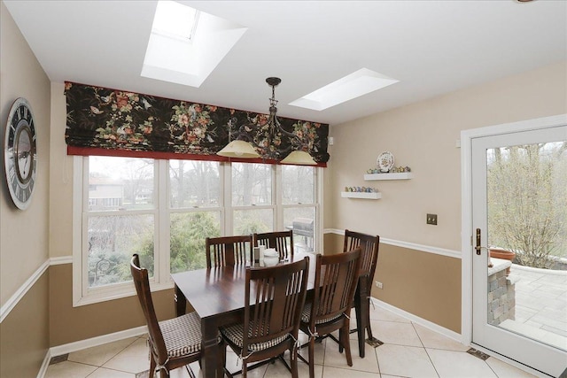 dining area with a skylight, plenty of natural light, and light tile patterned flooring