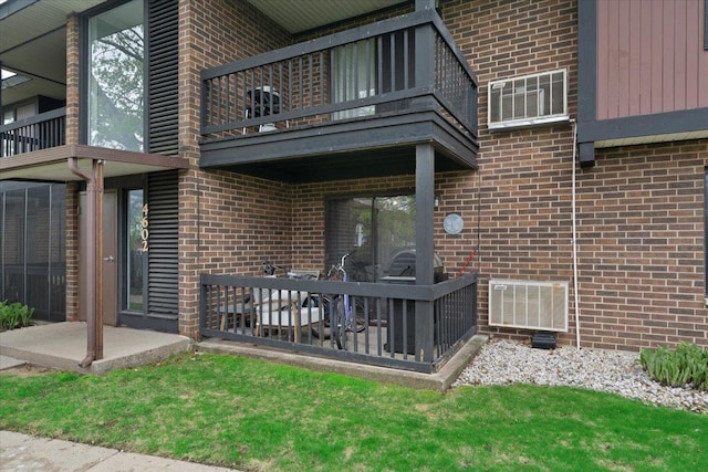 rear view of property featuring visible vents, a patio, brick siding, and a balcony
