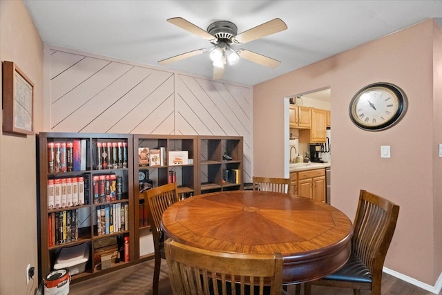 dining room featuring dark wood finished floors, baseboards, and a ceiling fan