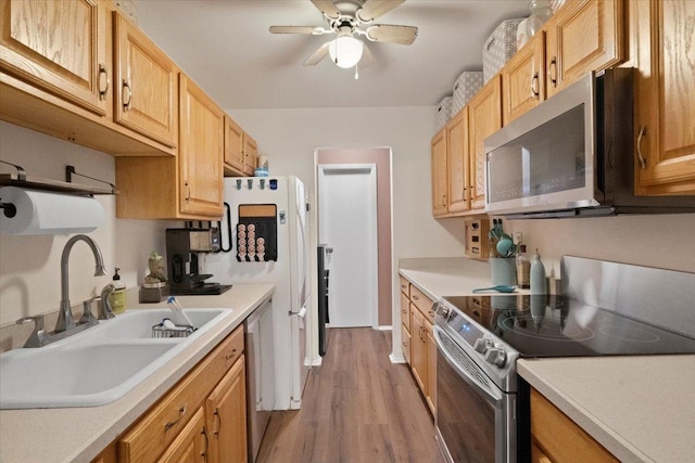 kitchen featuring a sink, stainless steel appliances, light countertops, and light wood-type flooring