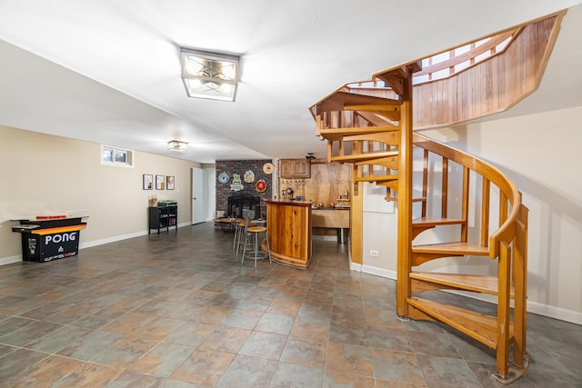 bar with stone finish flooring, baseboards, and stairs