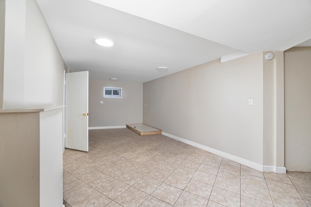 finished below grade area featuring baseboards and light tile patterned floors