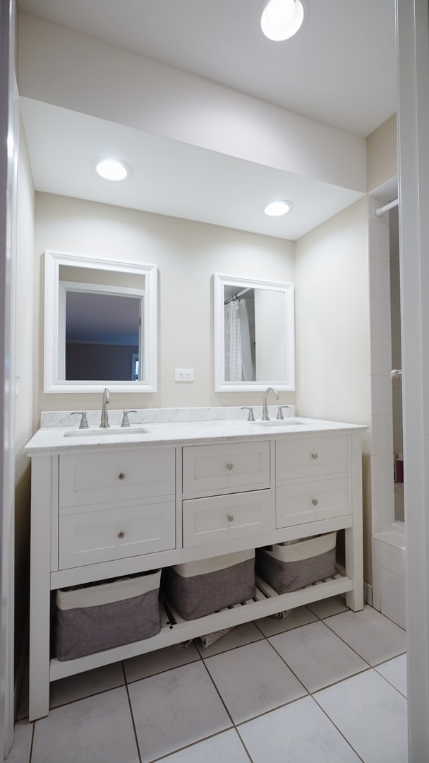 bathroom featuring double vanity, tile patterned floors, and a sink