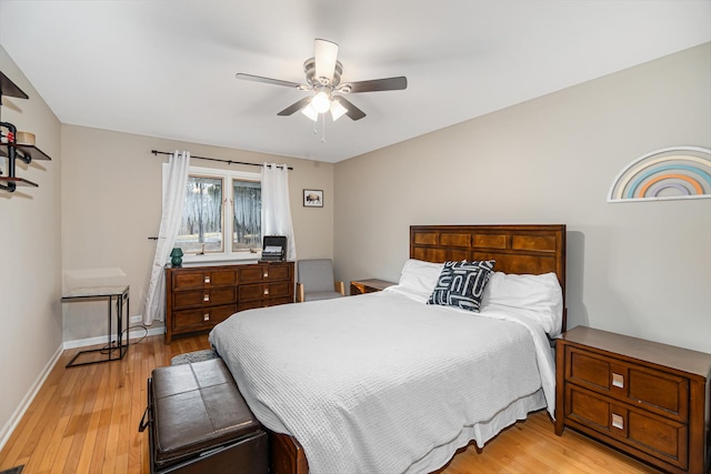 bedroom with light wood finished floors, baseboards, and ceiling fan