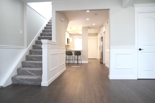interior space featuring recessed lighting, stairs, and dark wood-style flooring