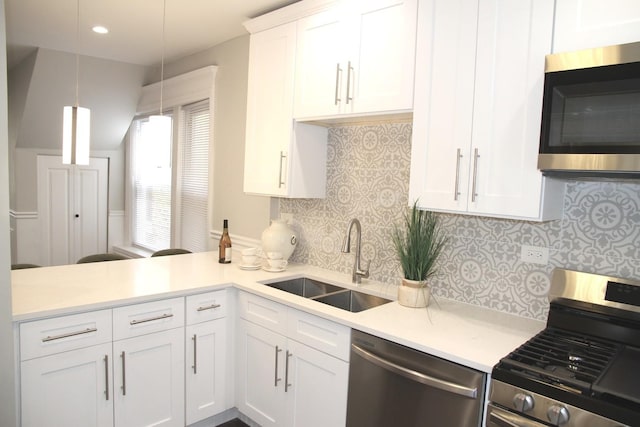 kitchen with white cabinets, stainless steel appliances, light countertops, and a sink
