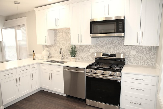 kitchen featuring a sink, stainless steel appliances, light countertops, white cabinetry, and dark wood-style floors