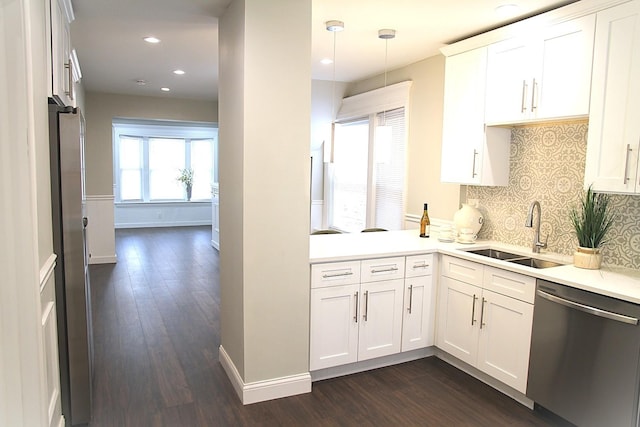 kitchen with dark wood finished floors, stainless steel appliances, white cabinets, and a sink