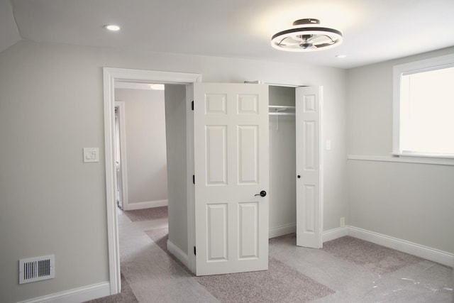 unfurnished bedroom featuring a closet, carpet, baseboards, visible vents, and recessed lighting