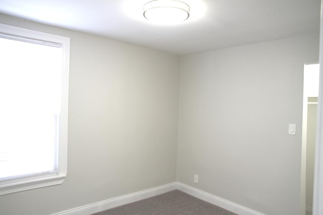 empty room featuring baseboards and carpet floors