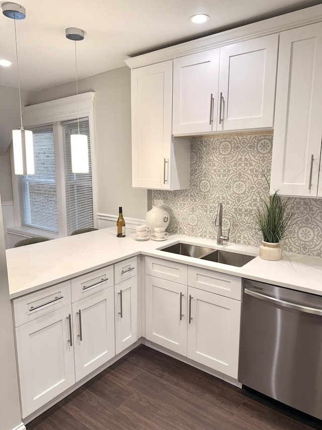 kitchen featuring a peninsula, stainless steel dishwasher, a sink, recessed lighting, and white cabinetry