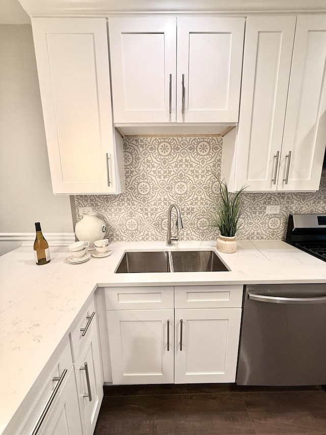kitchen with white cabinets, light stone countertops, a sink, and appliances with stainless steel finishes