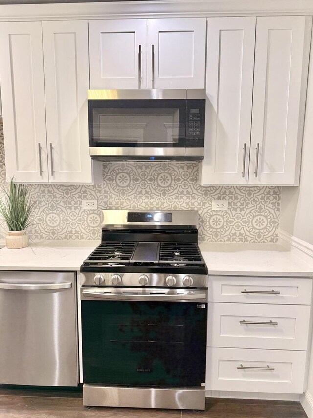 kitchen featuring white cabinets, light countertops, appliances with stainless steel finishes, and tasteful backsplash